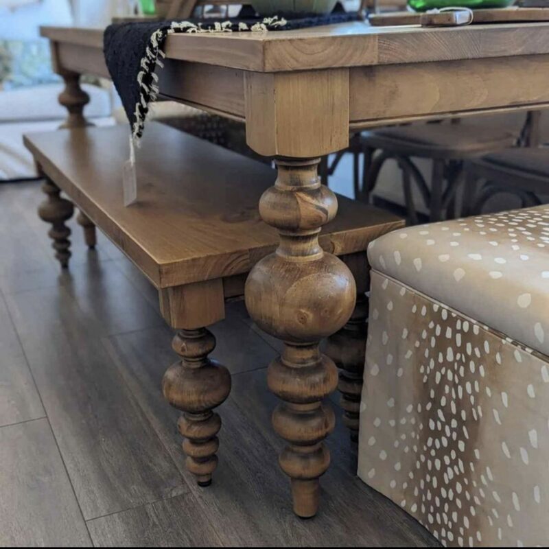 Wooden table and bench with ornate legs.