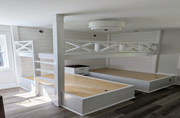 White bunk beds with storage in a room.