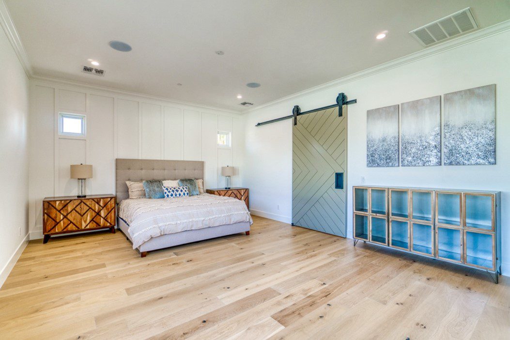 Bedroom with hardwood floors and sliding door.