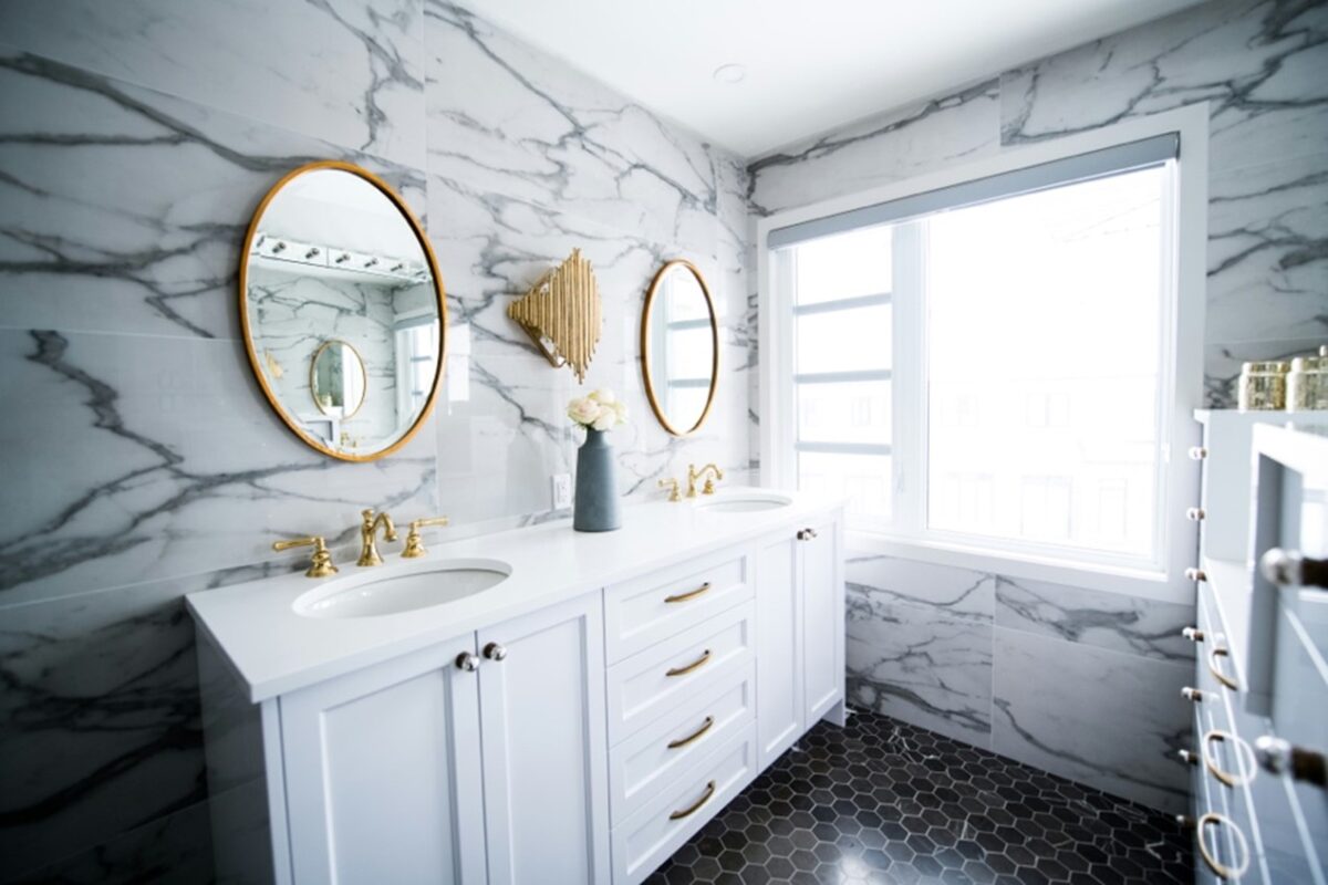 White bathroom vanity with marble tiles.