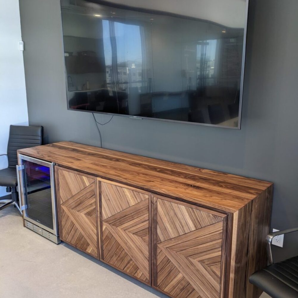 Wooden cabinet with TV and wine fridge.